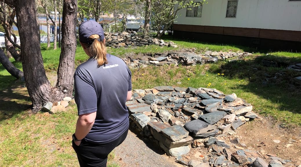 Woman looking at piles of stones in the grass